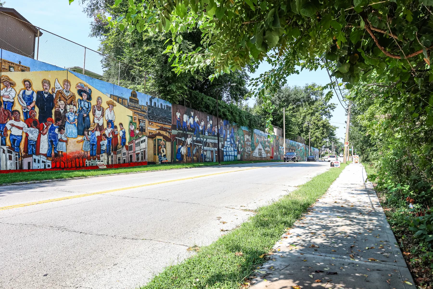 The Argentine neighborhood mural extending along a tree-lined street
